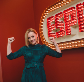 g-3 woman holds up arms in front of ESPN sign