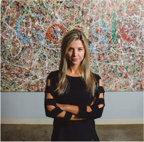 g-5 woman stands in front of an abstract painting